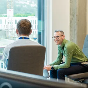 Menn i samtale i kontorlandskap